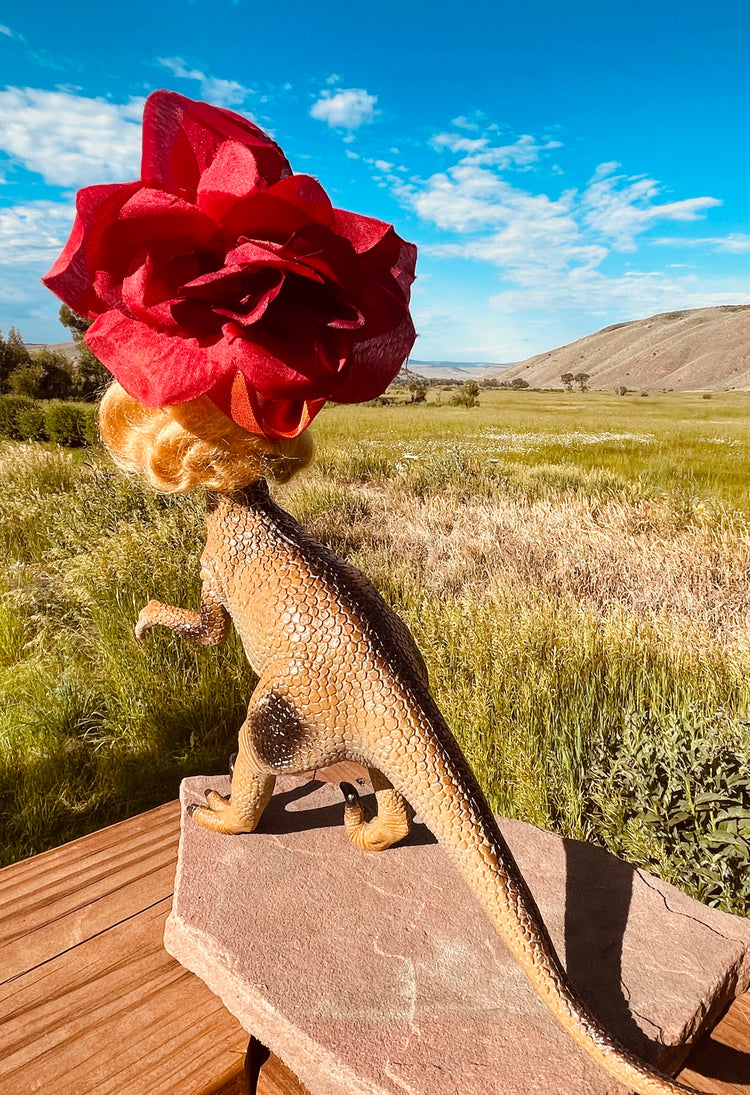 Backside, Vintage toy dinosaur with vintage doll head and flower headdress. 11" tall by 9" long and 4" across.