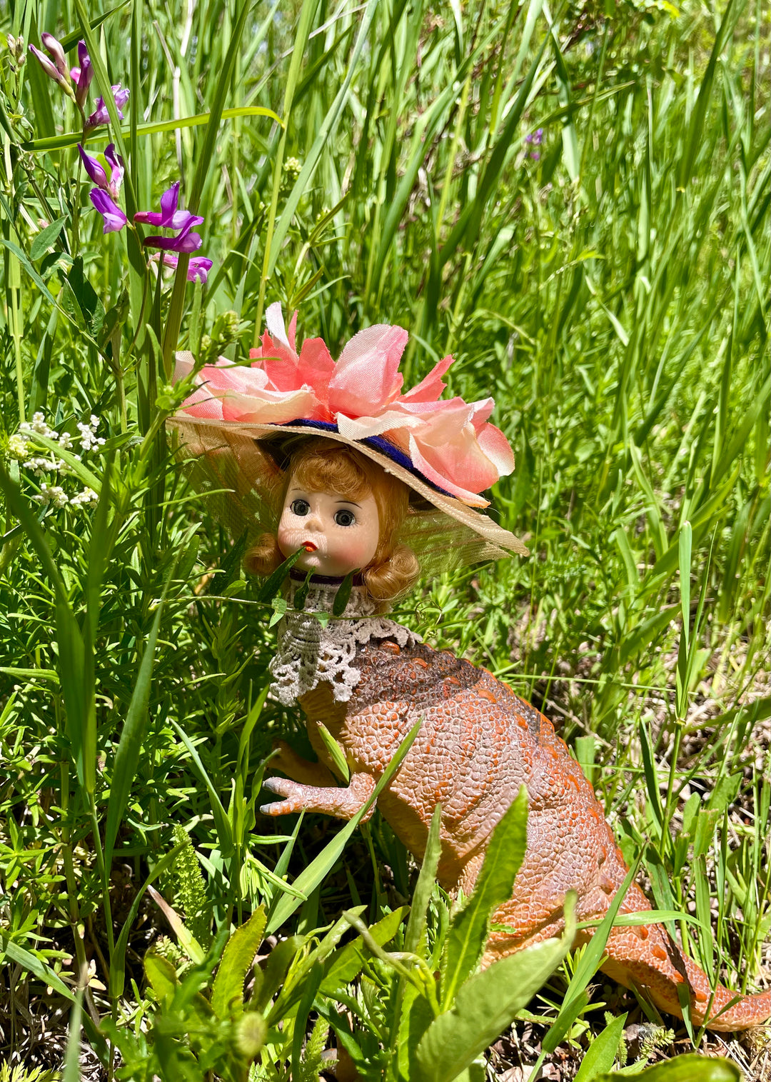 Vintage toy dinosaur body with Madame Alexander head, floral hat and lace neckline, 10" tall, 3" wide, 8" long.