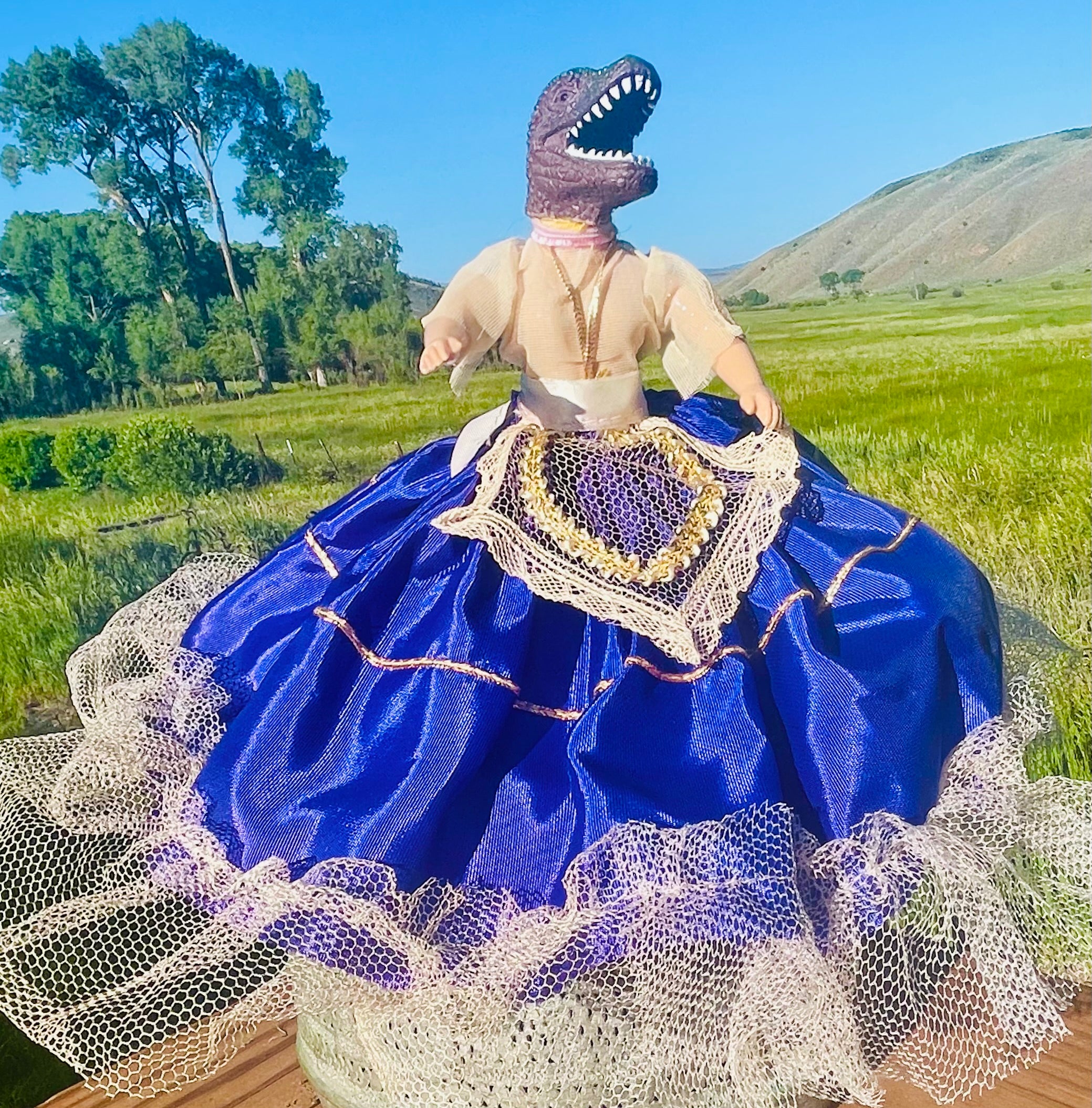 Vintage doll in a purple satin dress with tulle embellishments and a dinosaur head. 6" tall x 2" wide