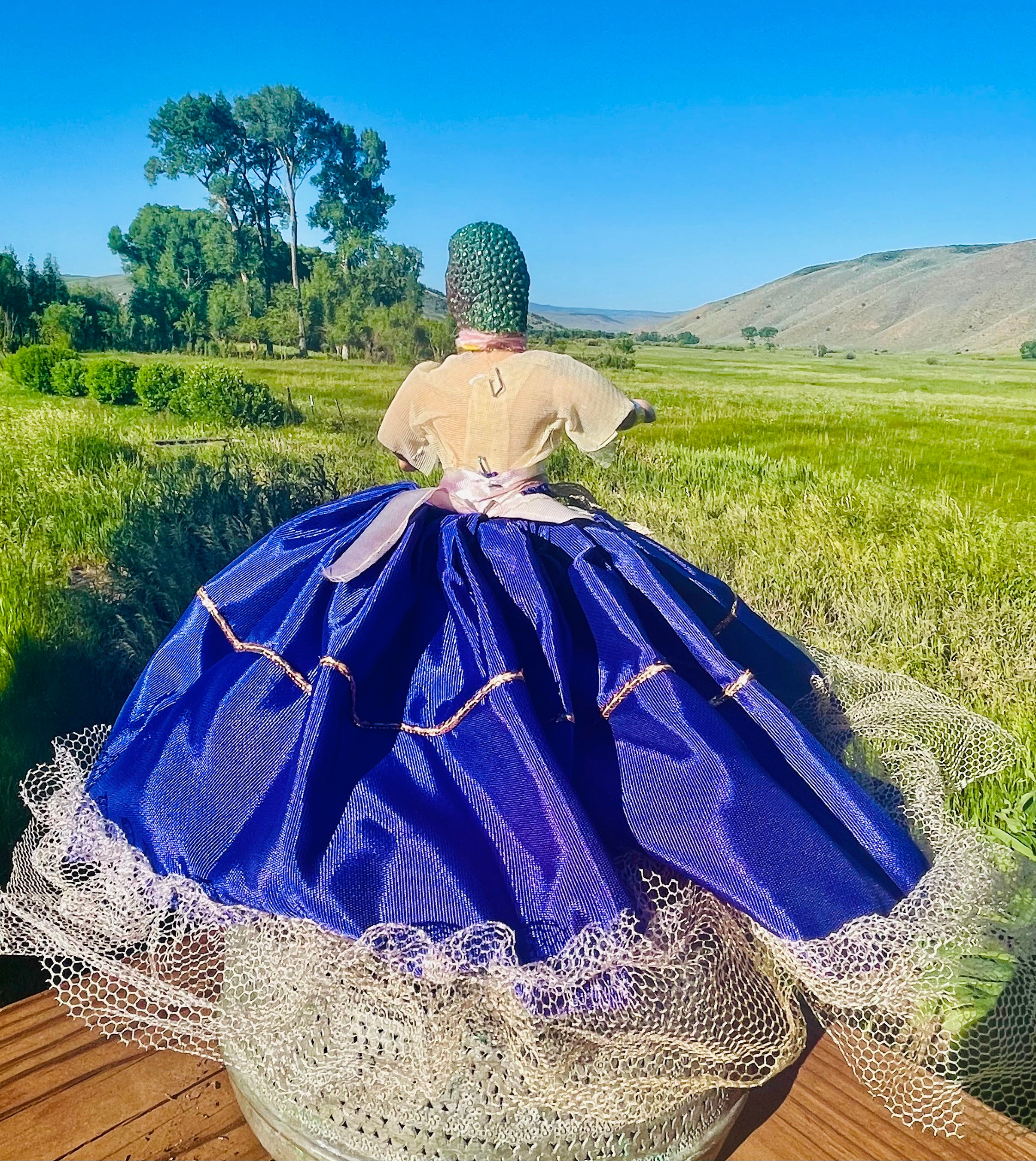 Backview, Vintage doll in a purple satin dress with tulle embellishments and a dinosaur head. 6" tall x 2" wide