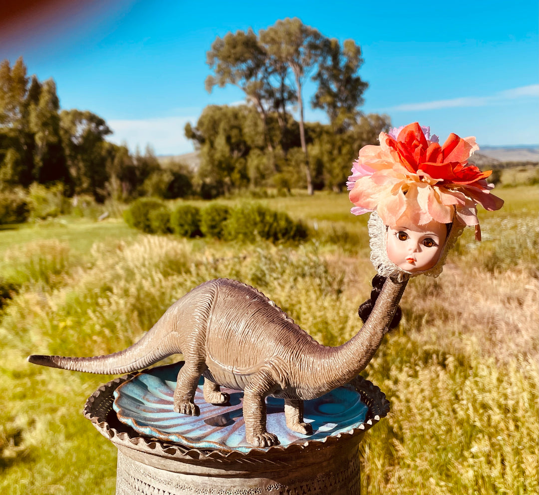 Vintage four legged toy dinosaur with Madame Alexander head and flower headdress