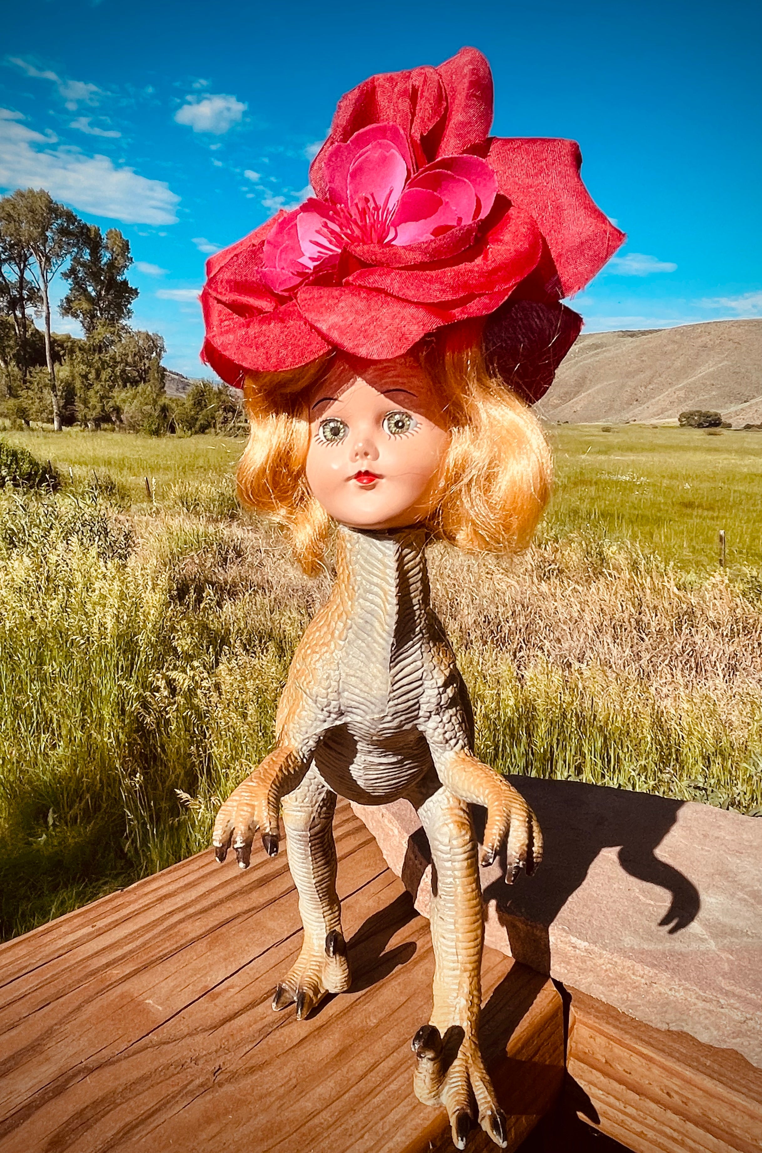 Vintage toy dinosaur with vintage doll head and flower headdress. 11" tall by 9" long and 4" across.