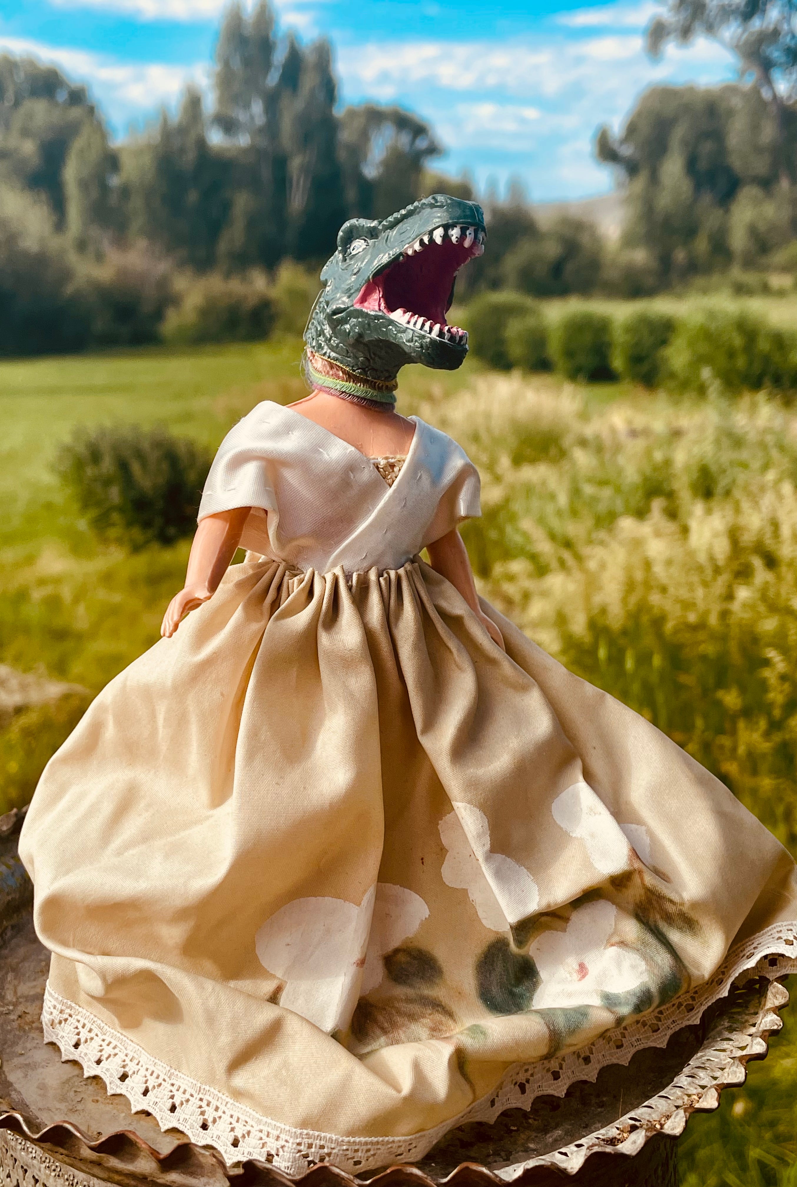 Vintage doll in a hand painted dress with a dinosaur head.