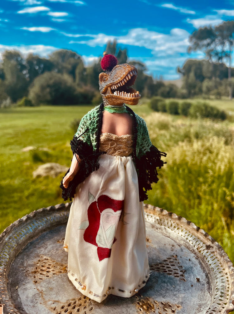 Vintage doll in a handpainted dress, crochet shawl and pom pom head adornment