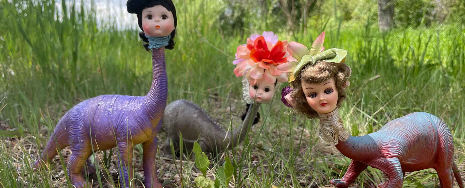 Three dinosaur dolls with brontosaurus bodies and human doll heads