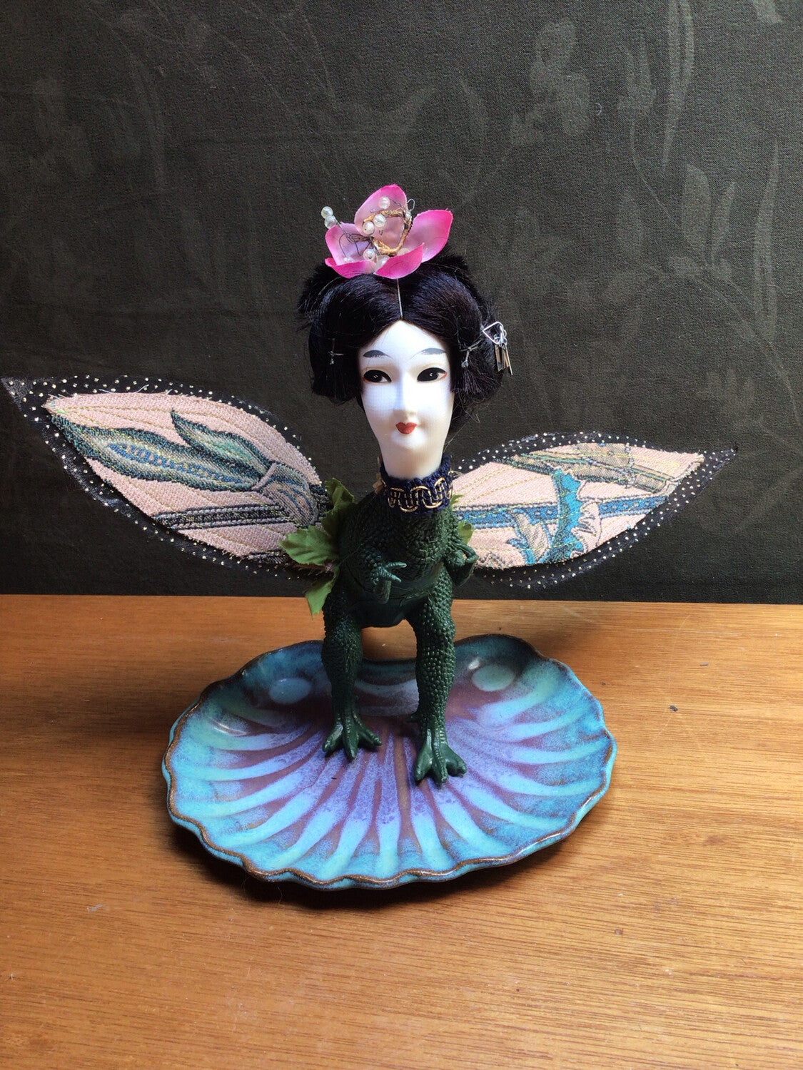 Elegant Geisha doll head on a dinosaur body with custom handcrafted wings of tapestry, gauze and gold thread. Flower headress. 7" tall x 7" wide with wings. 6" long . 
